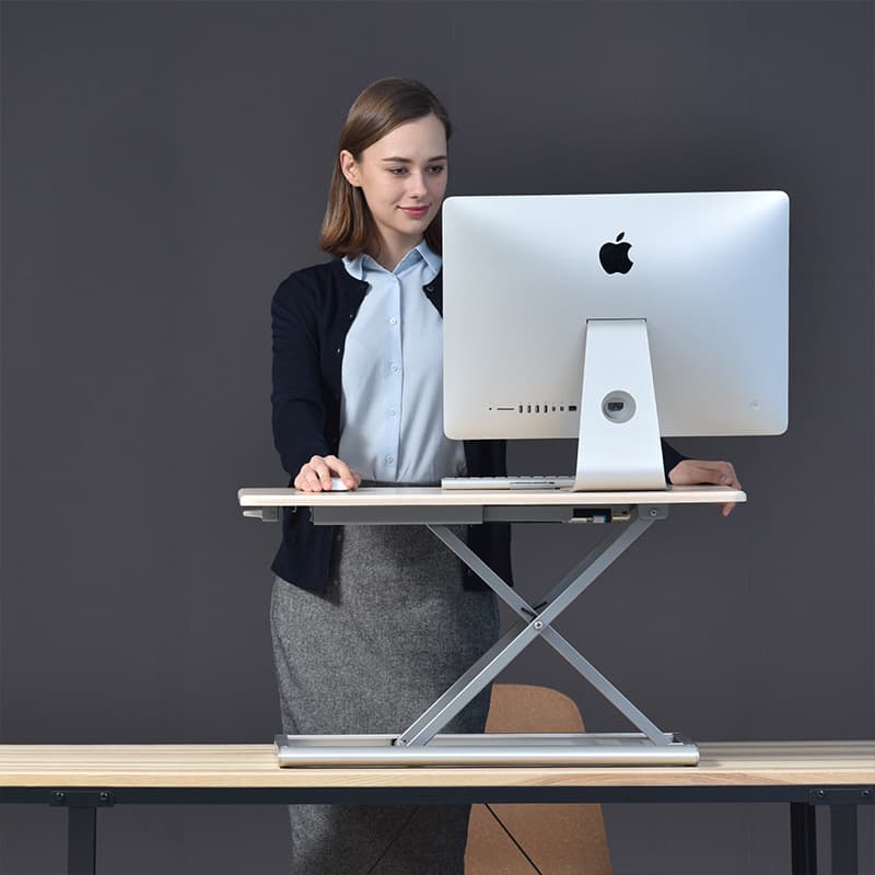 Standing and stretching at a height-adjustable desk during a movement break